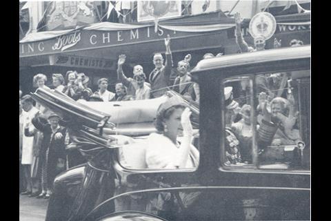 Queen Elizabeth II and the Duke of Edinburgh are greeted by crowds outside the Boots branch in Wellington, New Zealand, in 1954